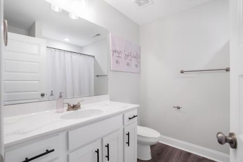 a white bathroom with a sink and a toilet at Waiting to Excell in Clarksville