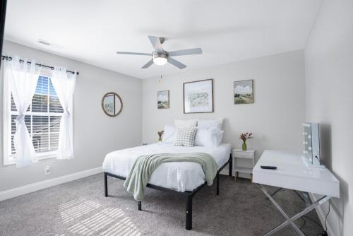 a white bedroom with a bed and a ceiling fan at Waiting to Excell in Clarksville