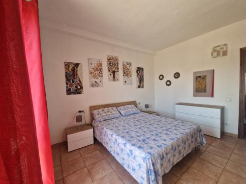 a bedroom with a bed and paintings on the wall at Casa Marina in Tortolì