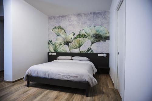 a bedroom with a bed with a painting on the wall at B&B del Parco in Cosenza