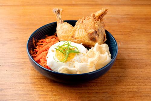 a bowl of food with a fried chicken and carrots at Anex Hotel near US Embassy in Manila