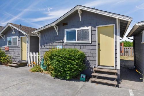 a blue house with a yellow door in a driveway at Arch View #7 in Long Beach