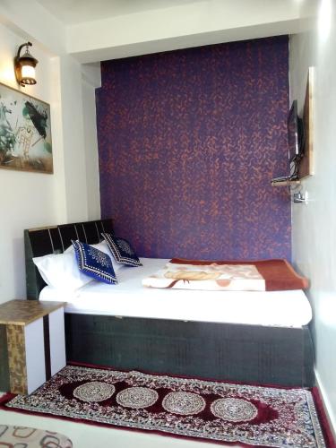 a bedroom with a bed with a purple wall at Om Datta Krupa Niwas Cottage in Mahabaleshwar