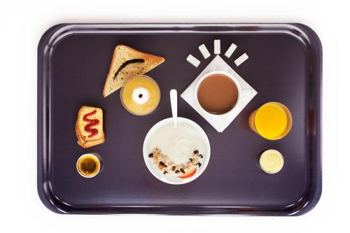 a black tray with breakfast foods on it at IBIS Budget Pontivy in Pontivy