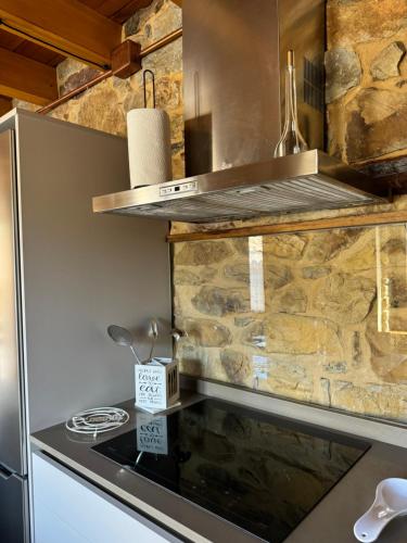 a kitchen with a stove and a stone wall at El Apartamentín de Verdiago in Verdiago
