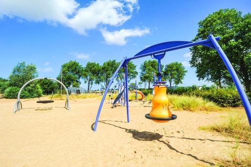 a park with a playground with a swing set at Kompas Camping Nieuwpoort in Nieuwpoort