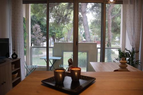 Cette chambre comprend une table avec deux tasses. dans l'établissement Jardin de Thau, à Balaruc-les-Bains