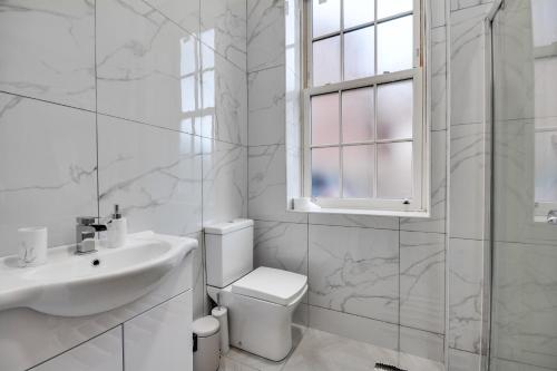 a white bathroom with a sink and a toilet at Wigan - Apartment - Sleeps 3 - Parking - Stadium in Wigan