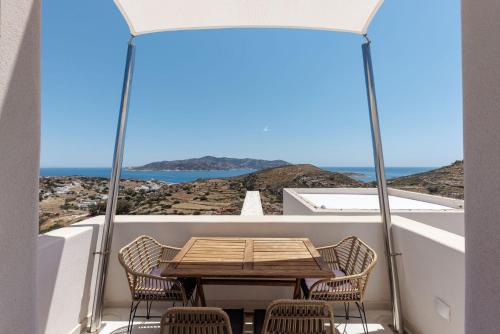a table and chairs on a balcony with a view of the ocean at ANEMOLETHE in Kimolos