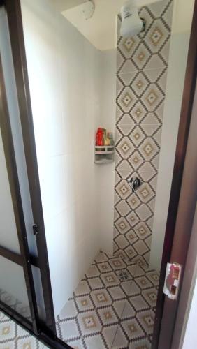 a small bathroom with a shower with a tile floor at Home Away in Sucre