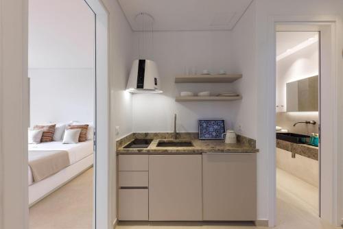 a kitchen with a sink and a bed in a room at ANEMOLETHE in Kimolos