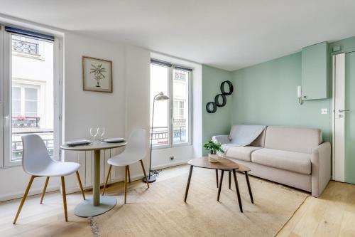 un salon avec un canapé, une table et des chaises dans l'établissement Montmartre l Center & Historic Sacré-Coeur, à Paris