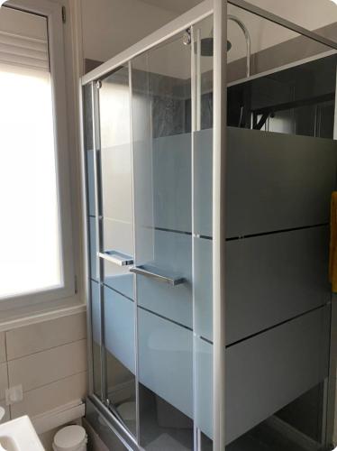 a glass cabinet in a bathroom with a toilet at La Pause Commingeoise in Saint-Gaudens