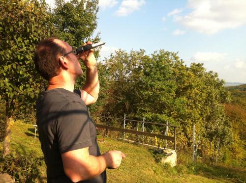 a man looking through a telescope on a hill at Traubengarten Winkler in Niederhollabrunn