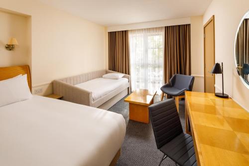 a hotel room with a bed and a desk at Sunday London Staines-upon-Thames Heathrow T5 in Staines