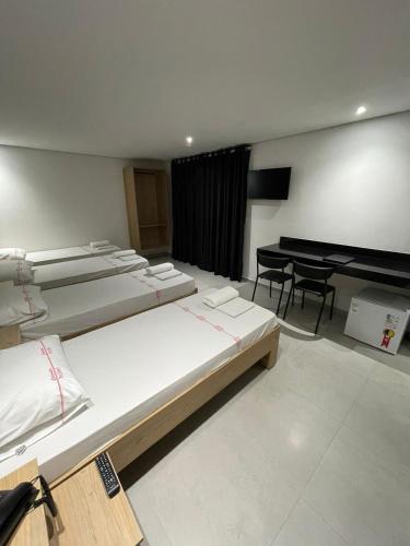 a group of beds in a room with a piano at Calandre Hotel in Sao Paulo