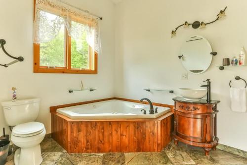 a bathroom with a wooden tub and a toilet at Stunning Home with Hot Tub Fire Pit & Amazing Views in Hunter