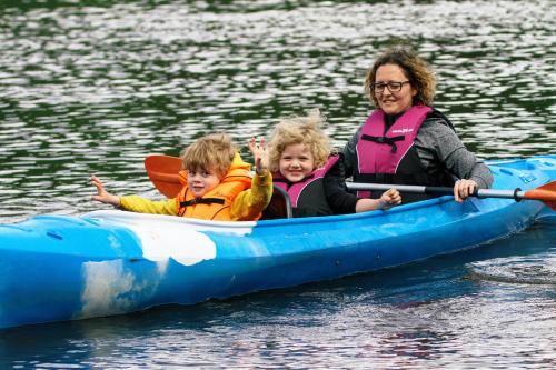 a woman and two children in a kayak on the water at Agroturystyka Wypoczynek nad Bugiem in Klepaczew