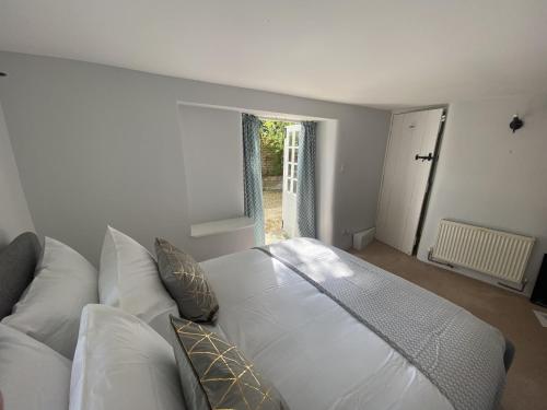 a white bed in a room with a couch at April Cottage in Hordle