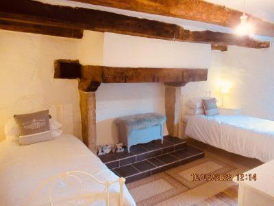 Cette chambre comprend 2 lits et une cheminée. dans l'établissement Trevejean chambre d'hotes de charme, à Guerlédan