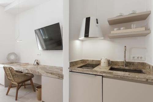 a kitchen with a sink and a tv on the wall at ANEMOLETHE in Kimolos