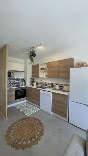 a kitchen with a white refrigerator and wooden cabinets at Le Clos Du Moulin 3, villa jardin, 3 chambres, près d'Avignon en Provence in Entraigues-sur-la-Sorgue