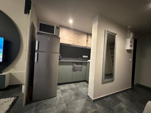 une cuisine avec un réfrigérateur et un micro-ondes dans l'établissement appartement Vitry sur Seine, à Vitry-sur-Seine