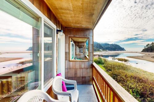 a balcony with two chairs and a view of the water at Coastal Tranquility in Neskowin
