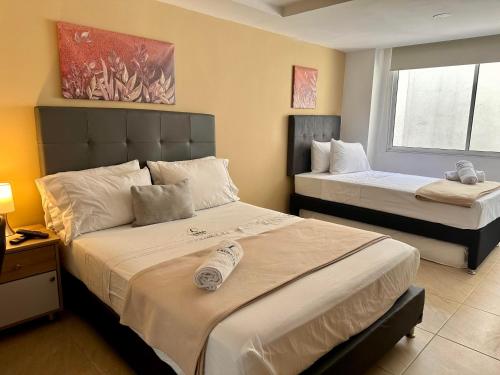 a hotel room with two beds and a window at Laureles Guest House LGH Hotel in Medellín