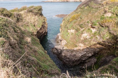 a body of water between two large rocks at 2 Bedroom Chalet With Sea Views in Plymouth