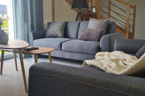 a living room with a blue couch and a table at Charmante maison raffinée, conviviale & familiale in Virandeville