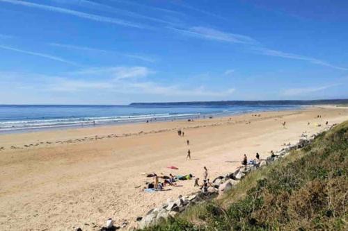 a group of people on a beach with the ocean at Charmante maison raffinée, conviviale & familiale in Virandeville