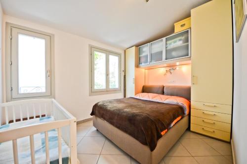 une petite chambre avec un lit et un berceau dans l'établissement Résidence Les Palmiers by Connexion, à Cannes
