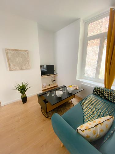 un salon avec un canapé bleu et une table dans l'établissement Le Temple 1, à Calais