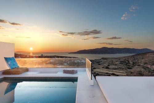 a villa with a swimming pool and a sunset at ANEMOLETHE in Kimolos