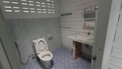 a bathroom with a toilet and a sink at Baan Suan Kayoo 2 Buffalo Bay Aow Khao Kwai in Ko Phayam