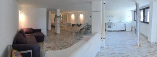 a living room with a staircase and a living room with a couch at Nido dell'Argentario - Porto Santo Stefano in Porto Santo Stefano