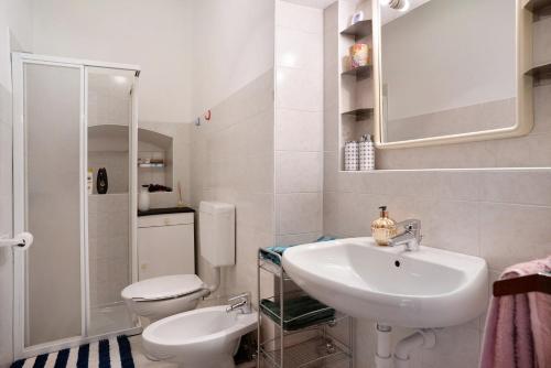 a white bathroom with a sink and a toilet at Svetlana e Cătălin in Pergine Valsugana