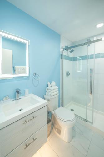 a bathroom with a toilet and a glass shower at Montauk Oceanside Suites in Montauk