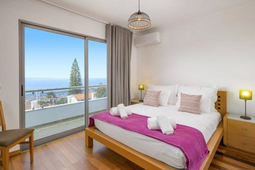 a bedroom with a large bed and a large window at Villa Atlantic Sunset by Villa Plus in Funchal