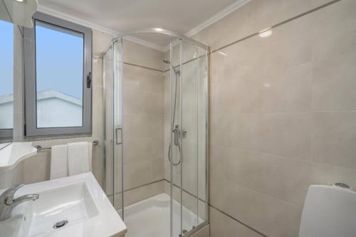 a bathroom with a glass shower and a sink at Villa Atlantic Sunset by Villa Plus in Funchal