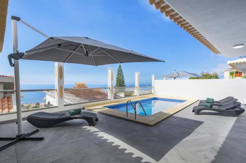 a patio with an umbrella and a swimming pool at Villa Atlantic Sunrise by Villa Plus in Funchal