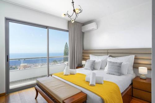 a bedroom with a large bed with a large window at Villa Atlantic Sunrise by Villa Plus in Funchal