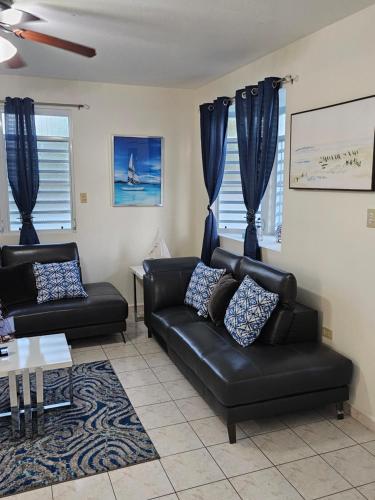 a living room with a black leather couch and a table at Casaplayuela in Camaceyes