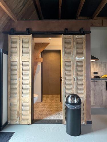 a door into a bathroom with a trash can at De Windpeluw - Daar bij die Kempermolen in Breedenbroek
