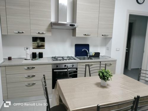 a kitchen with a table and a sink and a stove at casa vacanze in Tortoreto Lido