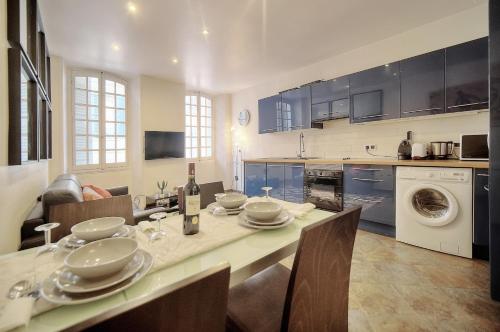 une cuisine avec une table et des chaises et une cuisine avec une machine à laver dans l'établissement 'JOLI 4 Pieces PROCHE VIEUX PORT' - A3B75, à Cannes