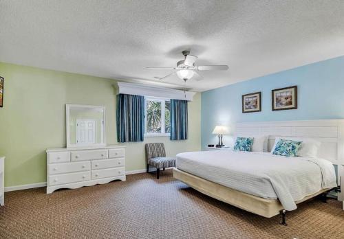a bedroom with a white bed and a window at Pelicans Reef by the beach in Myrtle Beach
