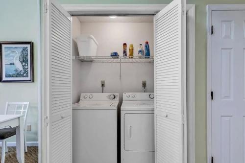 a white laundry room with two washes at Pelicans Reef by the beach in Myrtle Beach