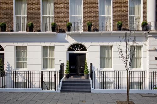 a white building with a black door and stairs at Cleveland Residences Russell Square in London